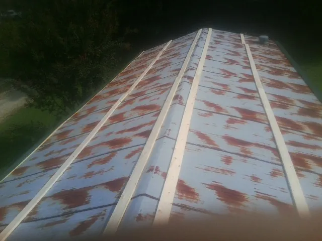 Rusted metal roof panels with new wood purlins before replacement — Storm Damage Roof Repair in Kesley by Roofing Brothers