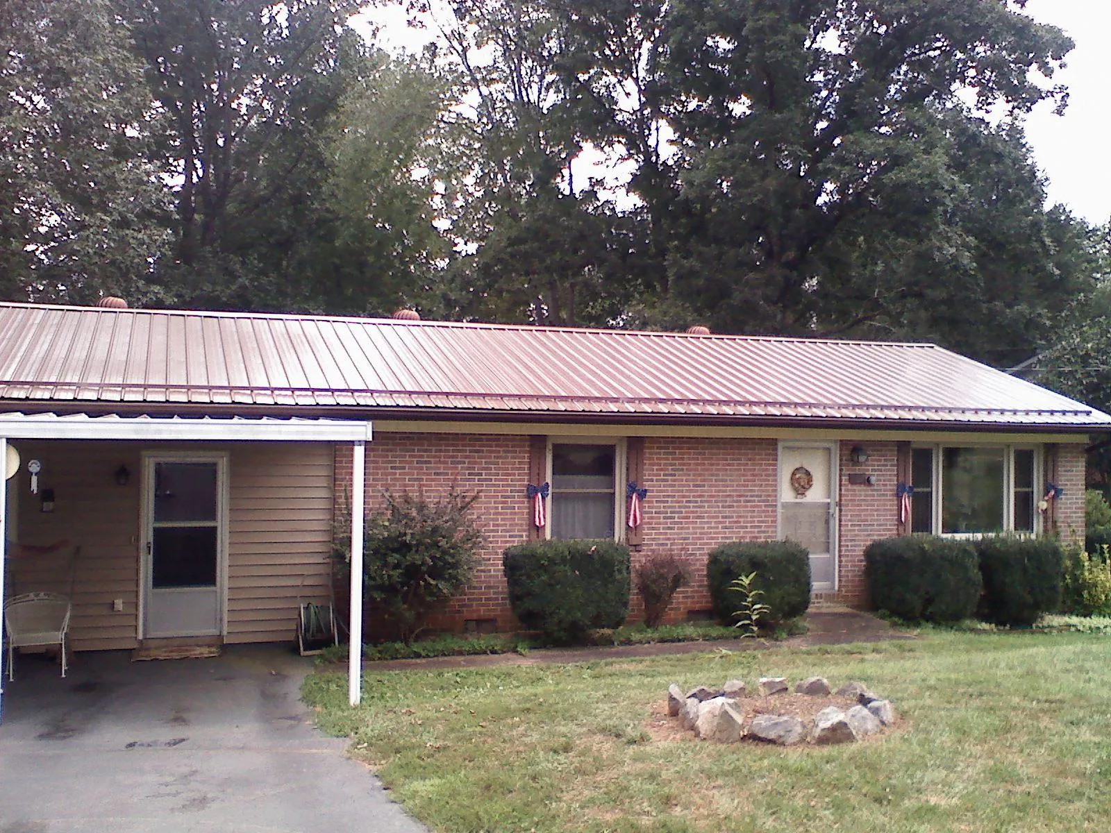 Bronze metal roof and carport on a brick ranch home — Roof Repair work by our crew in Kesley